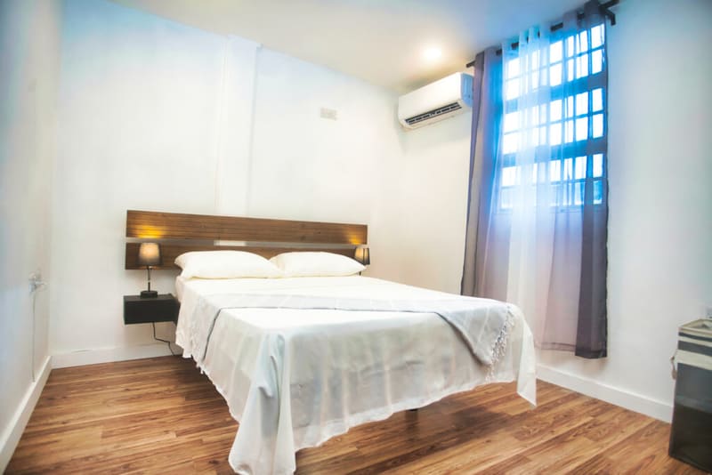 Second bedroom with warm wood bed frame and fresh linens